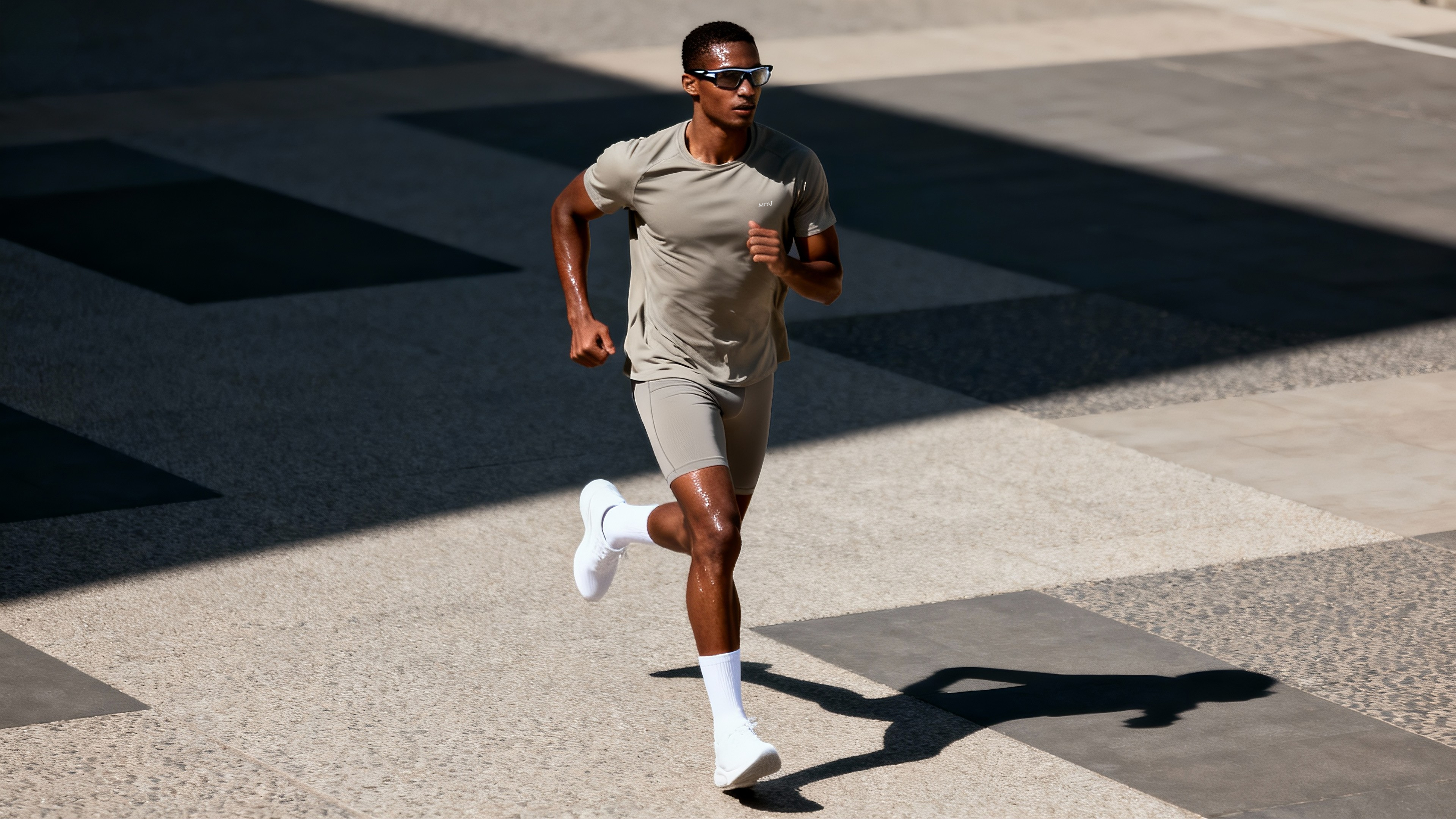 Atleta masculino corriendo con equipamiento deportivo en tonos beige
