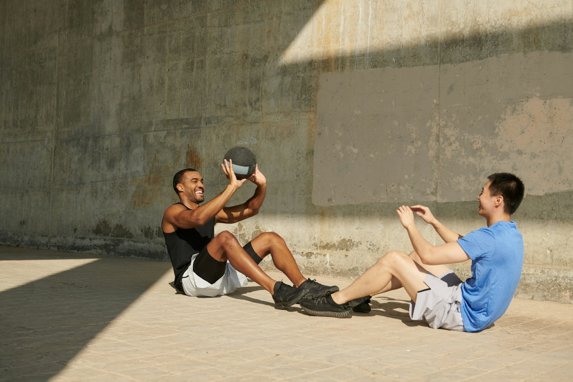 Dos hombres entrenando juntos en ejercicios de core en ambiente urbano