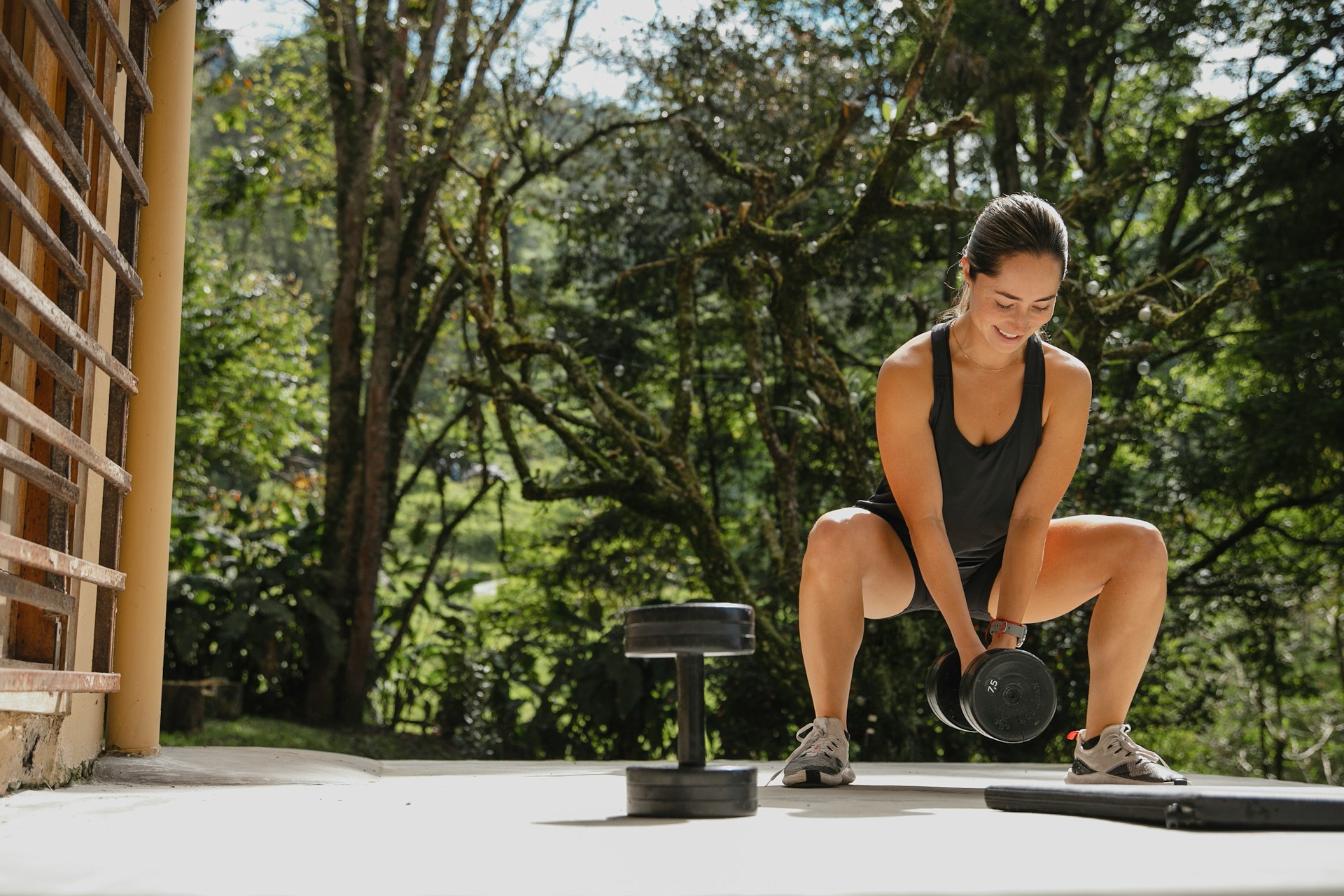 Mujer entrenando con mancuernas al aire libre